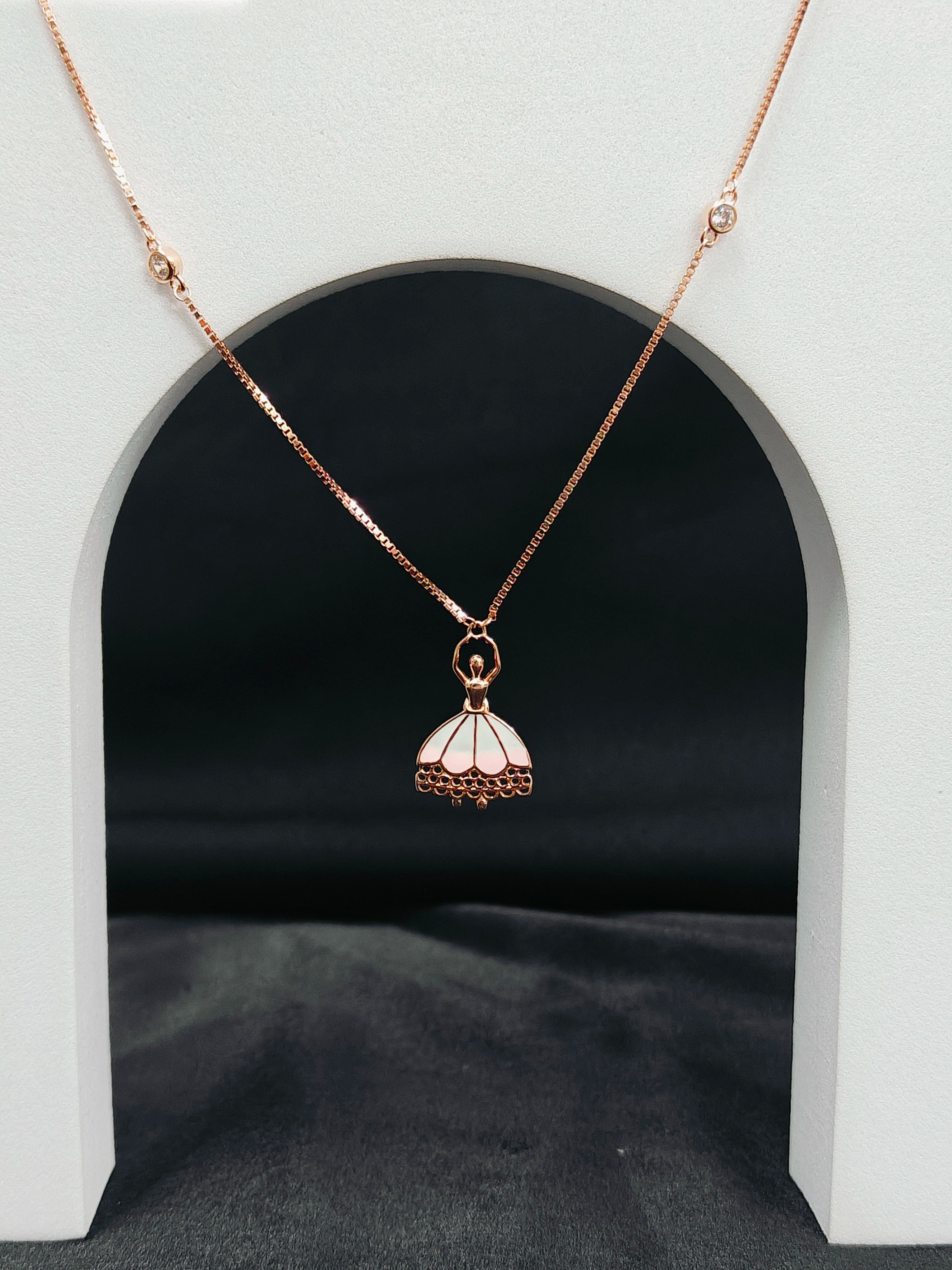 Rose gold necklace with a pendant on a white archway background